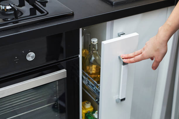 Woman hand open kitchen storage cabinet in modern interior