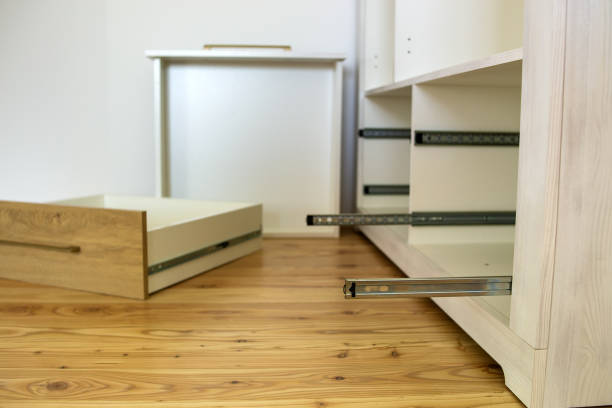Close up of installation of wooden drawer in contemporary cupboard cabinet.