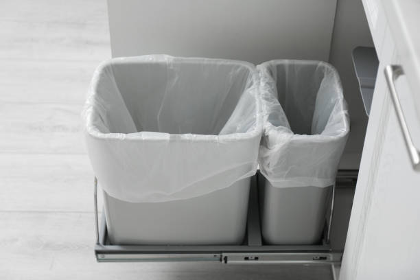 Open cabinet with empty trash bins for separate waste collection in kitchen