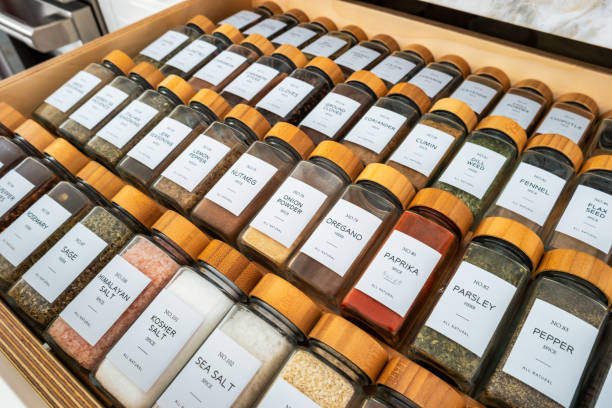 Large collection of glass spice containers in a drawer.